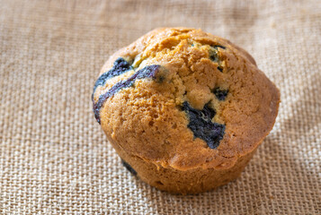 Blueberry muffin on hessian texture - selective focus