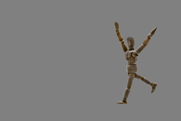Photograph of a dark coloured wooden mannequin with neutral gray coloured background. Photo to be...