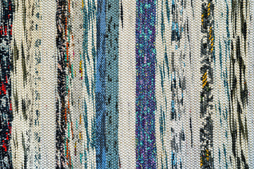 Texture of a multi-colored wicker floor carpet close-up. Abstract background.