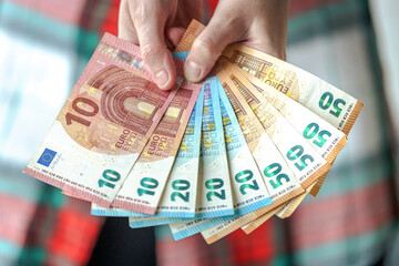 Woman showing euro banknotes of different value