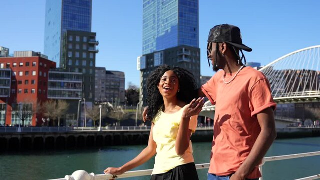 Young african american women in the city, lifestyle couple concept, walking laughing by the river