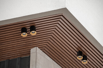 PVC ceiling panel covered with wood-like vinyl with modern lighting installed on it