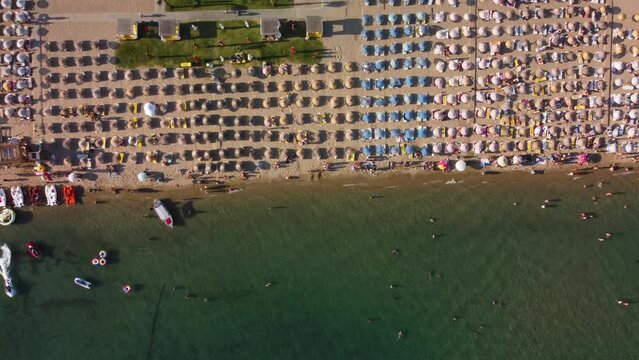 Top view of people sunbathing and swimming on the beach in sarimsakli ayvalik Balikesir Turkey. High quality 4k footage
