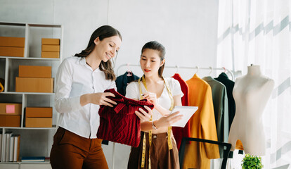 Diverse female fashion designers at work with tailor centimeters on necks and holds tablet and smartphone. independent creative design business. .