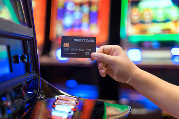 Slot Machine gambling bet Play Time. Female Gambler Hand hold credit card ready to win the game...