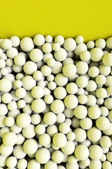 A large pile of abstract white spheres near a yellow wall. Background 3d rendering illustration.