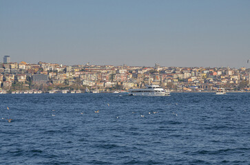 Fototapeta premium ferryboats on Bosporus strait and Anatolian side of Istanbul city view from Dolmabahce Palace pier