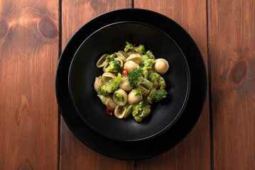 Piatto di deliziose orecchiette condite con broccoli e peperoncino, cibo italiano 