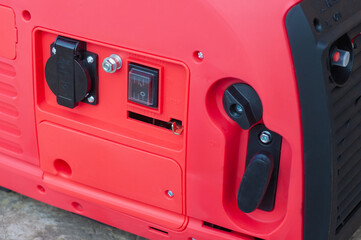 The red body of the electric gasoline generator from honda. Compact mobile voltage generator
