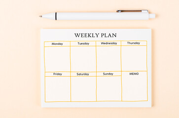 The Blank weekly plan notice block on yellow colour background. Empty schedule and a pen.