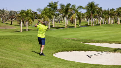 Golfer on a golf course, ready to tee off. Golfer with golf club hitting the ball for the perfect shot.