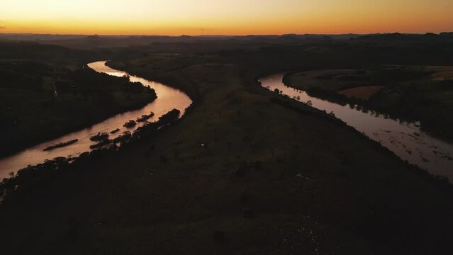 Flying over winding river at sunset amid green fields and forest. Volta do Dedo. Chapec&oacute; river. 4K.