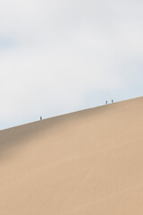 Minimal desert photography. People are walking on the mountain desert. Desert and sky minimal...