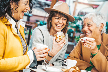 Three senior women enjoying breakfast drinking coffee at bar cafeteria - Life style concept with...