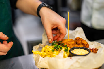 chef cooking Chicken Nuggets with French Fries and sauce on kitchen