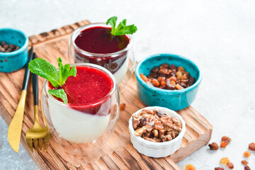 Dessert. Panna cotta with berry jam and mint. On a white plate. On a gray stone background. Restaurant menu.