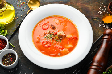 Bograch soup. Hungarian cuisine. Soup with meat, vegetables and chili peppers. In a white plate. Top view.