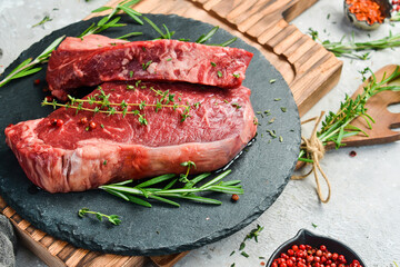 Aged juicy striploin steak. Meat. On a black stone background. Side view.