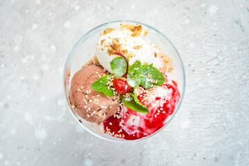 Balls of chocolate and strawberry ice cream in glasses. Top view. Free space for text.