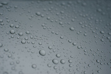 Drops of water on a gray background. Selective focus. Grey colour