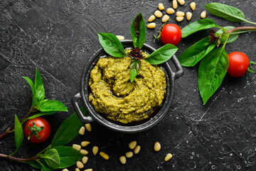Traditional pesto sauce. Ingredients: Basil, pine nuts, Parmesan and olive oil. On a black stone...