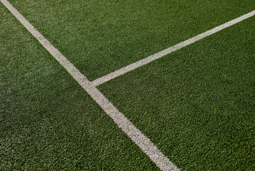 Sports field with green synthetic grass with a white and yellow line. Football, rugby, soccer,...