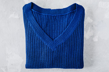 Sweater. Blue folded sweater on gray stone background.