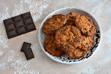 healthy oatmeal cookies with chocolate chips isolated on plate with chocolate bar