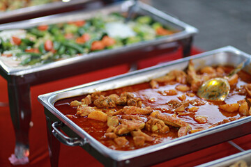 Asian buffet style delicacies served on warm trays during party