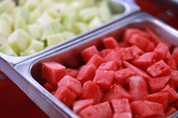 Fresh watermelon and honeydew melon served on buffet trays during party