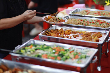 Asian buffet style delicacies served on warm trays during party
