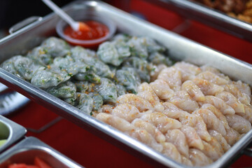 Steamed vegetables dumpling served on warm trays during party. Asian buffet style delicacies.