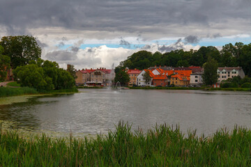 Fototapeta premium Colorful old town houses and church with lake reflection in Talsi Latvia.