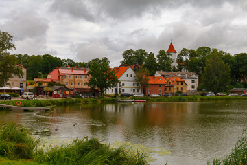 Naklejka na ściany i meble TALSI, LATVIA, SEPTEMBER 10, 2022: Colorful old town houses and church with lake reflection in Talsi Latvia.