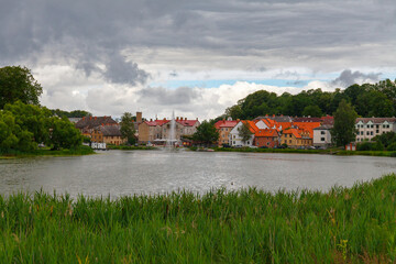 Fototapeta premium Colorful old town houses and church with lake reflection in Talsi Latvia.