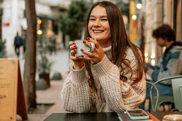 Stylish young woman drinking coffee at the coffee shop