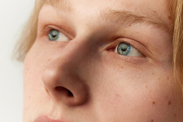 Close-up portrait of young redhead man with blue eyes. Eyes, nose. Vision care. Looking away....