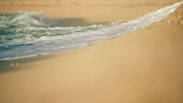 Sea waves on the sand beach, telephoto lens slow motion shot