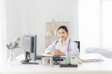 asian female doctor rest in her office, she reading and order treatment process on patient chart, she sitting and smile in hospital