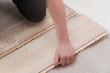 Professional worker installing new parquet flooring indoors, closeup