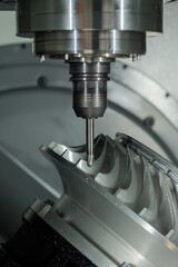 Close up: automated cnc vertical turning milling machine cutting metal workpiece at factory, exhibition, plant. Industrial, metalworking, engraving, equipment, technology and manufacturing concept