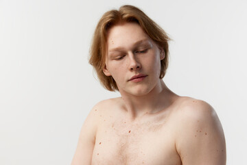 Natural make beauty. Moles on body. Portrait of young redhead man posing shirtless over grey studio background. Concept of men's health, body and skin care, hygiene and male cosmetology