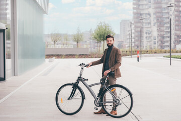 Contemporary bearded young man biking outdoors city commuting the carbon-free way