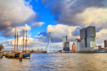 Cityscape of Rotterdam - view of the moored sailboat and the Erasmus Bridge with Tower blocks in the Kop van Zuid neighbourhood, South Holland, The Netherlands