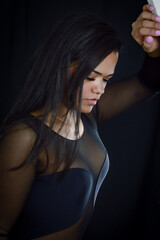 Portrait of a beautiful young Brazilian woman leaning against a wall and looking down tired