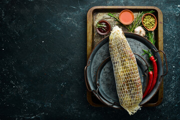 Dried veal beef with spices and herbs. On a black stone background. Top view. Free space for text.