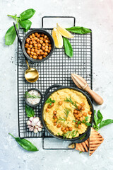 A bowl of hummus. Chickpea hummus and olive oil with spices. Top view. On a concrete background.