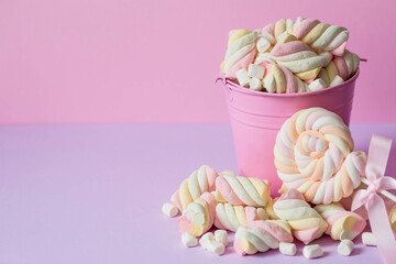 Marshmallows. Chewing candy close-up on a pink background. Dessert of sweet dishes in a pink bucket. Pastel colors. A copy of the text space.