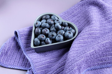Fresh blueberries in a heart-shaped bowl.