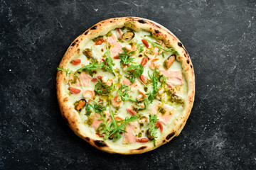 Italian pizza with seafood and cheese. Takeaway food. On a black stone background. Rustic style.